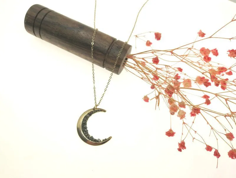 Irregular crescent moon necklace with diamonds and a snake bone chain.