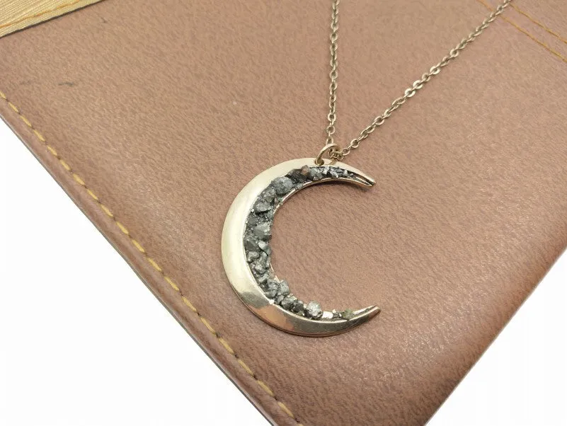 Irregular crescent moon necklace with diamonds and a snake bone chain.