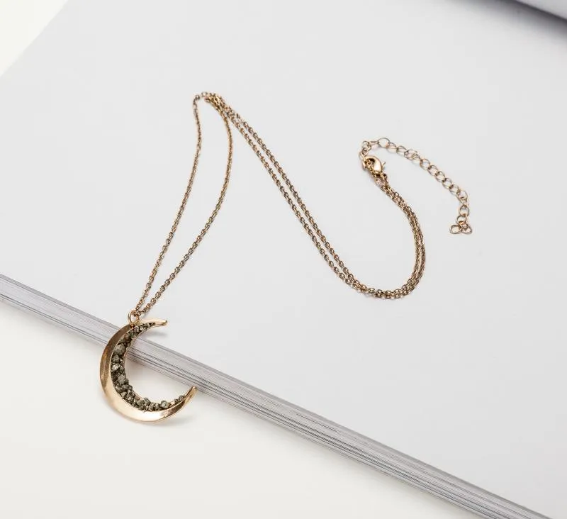 Irregular crescent moon necklace with diamonds and a snake bone chain.